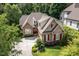 Beautiful home with brick and stone accents, red shutters, and lush green lawn at 605 Bear Tree Crk, Chapel Hill, NC 27517