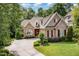 Charming brick and stone home with well-manicured landscaping and a concrete driveway at 605 Bear Tree Crk, Chapel Hill, NC 27517