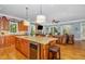 Open concept kitchen with a center island, connecting to a living room with a stone fireplace at 605 Bear Tree Crk, Chapel Hill, NC 27517