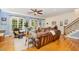 Spacious living room featuring hardwood floors, a leather sofa, and large windows at 605 Bear Tree Crk, Chapel Hill, NC 27517