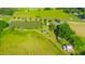 Aerial view of the property featuring a pond, barn, surrounding trees and fields at 623 Chambers Rd, Rougemont, NC 27572