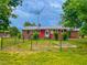 Red home with metal roof featuring fenced in backyard and mature trees on a large lot at 623 Chambers Rd, Rougemont, NC 27572