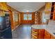 Bright dining area with wood-paneled walls and large windows, adjacent to the kitchen at 623 Chambers Rd, Rougemont, NC 27572