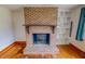 Classic brick fireplace with built-in shelving and hardwood floors at 623 Chambers Rd, Rougemont, NC 27572