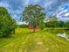 Pastoral view of a red barn and pond on sprawling land with lush green grass and mature trees at 623 Chambers Rd, Rougemont, NC 27572