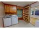 Functional laundry room with washer, dryer, and built-in storage shelves at 623 Chambers Rd, Rougemont, NC 27572
