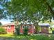 This beautiful home features a red exterior, carport, and a spacious backyard surrounded by lush greenery at 623 Chambers Rd, Rougemont, NC 27572