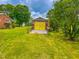 Wooden shed with yellow doors and adjacent to the home, surrounded by a lush, green lawn at 623 Chambers Rd, Rougemont, NC 27572
