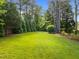 Well-maintained backyard featuring a lush green lawn and towering trees for the perfect serene outdoor experience at 6648 Mafolie Ct, Raleigh, NC 27613