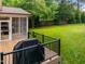 Spacious backyard deck with black railings and grill, overlooking the beautifully manicured lawn and lush trees at 6648 Mafolie Ct, Raleigh, NC 27613