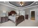 Large primary bedroom showcasing tray ceiling, bedside tables, and easy access to Primary bath at 6648 Mafolie Ct, Raleigh, NC 27613