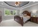 Spacious primary bedroom with detailed tray ceiling, large windows, and neutral carpet at 6648 Mafolie Ct, Raleigh, NC 27613