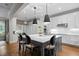 Open kitchen with island, barstool seating, stainless appliances, and seamless access to the dining area at 6648 Mafolie Ct, Raleigh, NC 27613