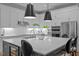 Bright kitchen boasting quartz countertops, white cabinetry, and designer pendant lights at 6648 Mafolie Ct, Raleigh, NC 27613