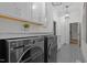 Chic laundry room showcasing front-load washer and dryer with custom cabinetry and lighting at 6648 Mafolie Ct, Raleigh, NC 27613