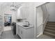 Well-lit laundry room with patterned tile, folding rack, sink, and modern appliances at 6648 Mafolie Ct, Raleigh, NC 27613