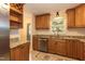 Well-lit kitchen featuring granite countertops, stainless steel appliances, and wooden cabinets at 6685 English Ivy Ln, Raleigh, NC 27615