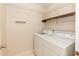Functional laundry room equipped with a washer, dryer, and wire shelving for storage at 6685 English Ivy Ln, Raleigh, NC 27615