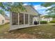 Backyard featuring a screened porch, patio area with grill, and lawn with greenery at 804 Harsworth Dr, Cary, NC 27519