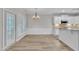 Open dining area featuring wood floors, stylish chandelier, wainscoting and easy access to the kitchen and outdoor area at 804 Harsworth Dr, Cary, NC 27519