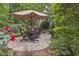 Beautiful patio with umbrella table surrounded by lush foliage at 826 Rushing, Pittsboro, NC 27312