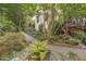 Beautifully landscaped backyard featuring stone pathways, lush greenery, and tasteful decorations at 826 Rushing, Pittsboro, NC 27312