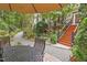 Lush backyard oasis featuring a stone patio with outdoor seating and a garden with wooden staircase at 826 Rushing, Pittsboro, NC 27312