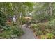 Beautifully landscaped backyard with stone path leading to outdoor seating area at 826 Rushing, Pittsboro, NC 27312