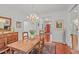 Formal dining room with wood table, chandelier, and view of entry foyer with a bright red door at 826 Rushing, Pittsboro, NC 27312