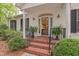 Close-up of front porch showing brick steps, glass front door, and manicured landscaping at 826 Rushing, Pittsboro, NC 27312