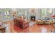 Bright and airy living room with a fireplace, leather seating, and large windows with white shutters at 826 Rushing, Pittsboro, NC 27312