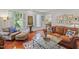 Elegant living room featuring leather furniture, large windows with shutters, and stylish decor at 826 Rushing, Pittsboro, NC 27312