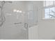 Modern bathroom shower with white subway tiles, glass enclosure, and window offering natural light at 826 Rushing, Pittsboro, NC 27312
