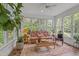 Bright sun room with lots of windows, wicker furniture, ceiling fan and potted plants at 826 Rushing, Pittsboro, NC 27312