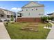 Spacious backyard with garden beds on green grass, a brick foundation, and a screened in porch at 986 Gateway Commons Cir, Wake Forest, NC 27587