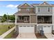Exterior view of townhome featuring a two-car garage, porch, and neutral colored siding at 986 Gateway Commons Cir, Wake Forest, NC 27587