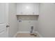 Bright laundry room with tiled floor, white cabinets, and necessary hookups at 986 Gateway Commons Cir, Wake Forest, NC 27587