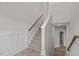 View of carpeted stairway featuring a wood handrail and paneled wall; doorway in the background at 986 Gateway Commons Cir, Wake Forest, NC 27587