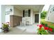 Relaxing front porch with brick accents, rocking chair, and colorful potted flowers at 1009 Morrison Dr, Durham, NC 27703