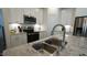 Close-up of the kitchen island featuring a double sink and granite countertop with stainless steel appliances at 1009 Morrison Dr, Durham, NC 27703