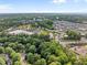 Aerial view displays the property's surrounding neighborhood, pond, trees, and nearby commercial areas at 1013 New Chester Ct, Apex, NC 27502