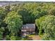 Aerial shot of a brick home surrounded by lush greenery and mature trees in a serene neighborhood at 1013 New Chester Ct, Apex, NC 27502