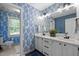 Well-decorated bathroom featuring a double vanity, blue wallpaper, and ample lighting at 1013 New Chester Ct, Apex, NC 27502