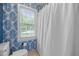 Cozy bathroom with blue wallpaper and a shower-tub combination with natural light at 1013 New Chester Ct, Apex, NC 27502