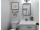 Cozy bathroom featuring gray walls, modern mirror, and bright white vanity sink with black hardware at 1013 New Chester Ct, Apex, NC 27502