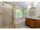 Bathroom with shower, tub, and vanity, with natural lighting from window at 1013 New Chester Ct, Apex, NC 27502