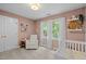 Charming bedroom with a crib, soft chair, and natural light from the window at 1013 New Chester Ct, Apex, NC 27502