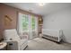 Comfortable bedroom with a crib, soft chair, and natural light from the window at 1013 New Chester Ct, Apex, NC 27502