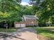 Beautiful brick home with mature trees, a spacious driveway, and a two-car garage at 1013 New Chester Ct, Apex, NC 27502