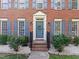 Elegant front door with a wreath, blue shutters, and manicured landscaping at 1013 New Chester Ct, Apex, NC 27502